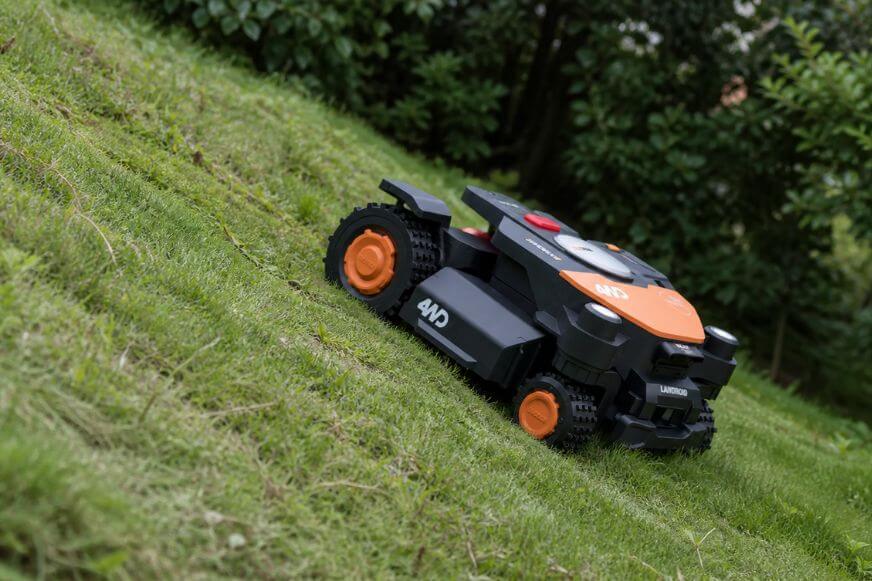 Mähroboter mit Allradantrieb fährt auf einen 80% steilen Gartenhang bergauf